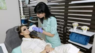 美容师对病人面部进行激光脱毛。 脱毛程序